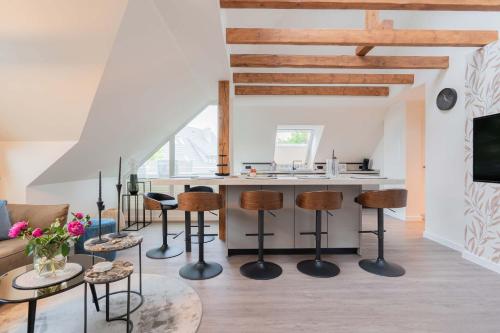 eine Küche und ein Wohnzimmer mit einer Theke und Stühlen in der Unterkunft Neywatt 1 in Norderney