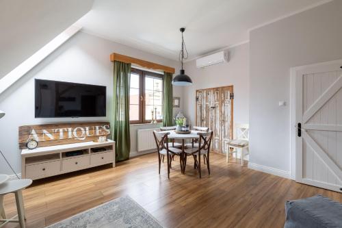 ein Wohnzimmer mit einem Tisch und einem TV in der Unterkunft Apartament Wigilijna Premium Starówka in Elblag