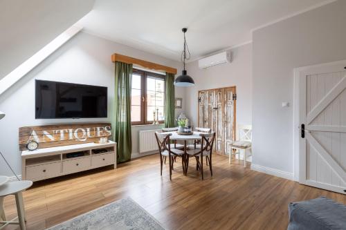 a living room with a table and a tv at Apartament Wigilijna Premium Starówka in Elblag