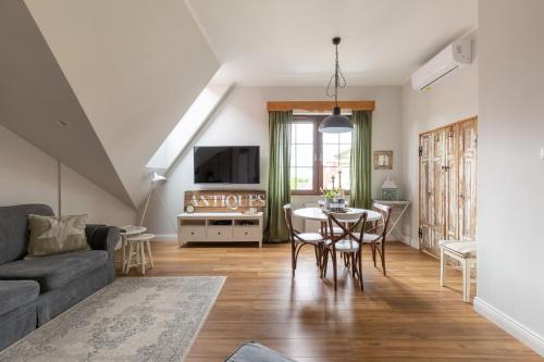 uma sala de estar com uma mesa e um sofá em Apartament Wigilijna Premium Starówka em Elblag