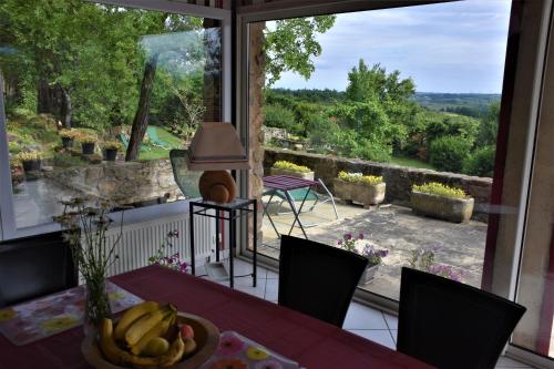 comedor con mesa y ventana grande en Chambre d'hôtes de Thorée, en Maclas