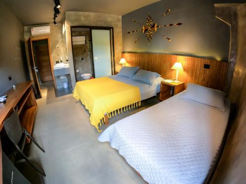 a bedroom with two beds and a mirror at Villa'l Mare Hotel in Maresias