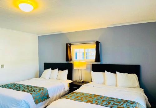 a hotel room with two beds and a window at Wells Moody Motel in Wells