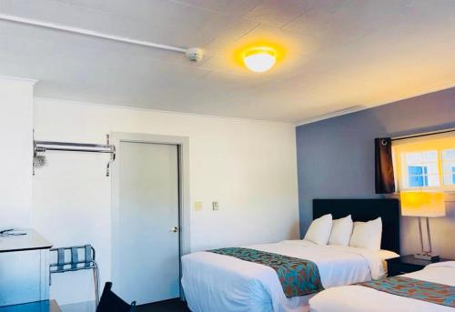 a hotel room with two beds and a table at Wells Moody Motel in Wells