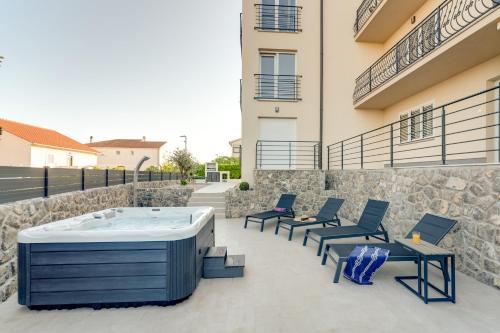 - un bain à remous sur une terrasse à côté d'un bâtiment dans l'établissement Cosmopolitan Apartments, à Krk