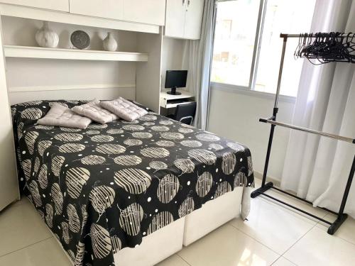 Schlafzimmer mit einem Bett mit einer schwarzen und weißen Bettdecke in der Unterkunft MARCOLINI - Luxo Vista Mar - Praia do Pepê in Rio de Janeiro