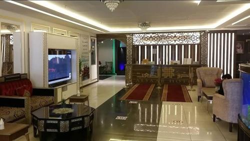 a living room with a couch and a tv in it at روائع للشقق المخدومة in Taif