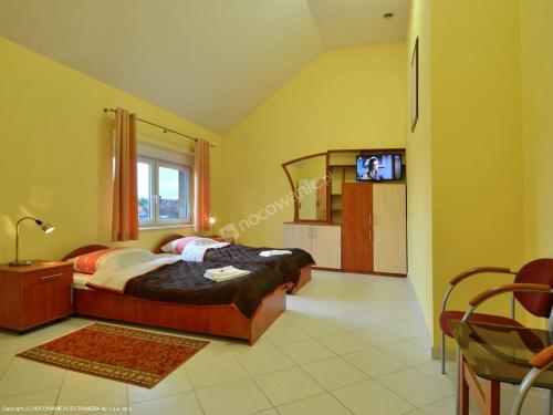 a bedroom with a bed and a television in it at Villa Paradiso in Wrocław