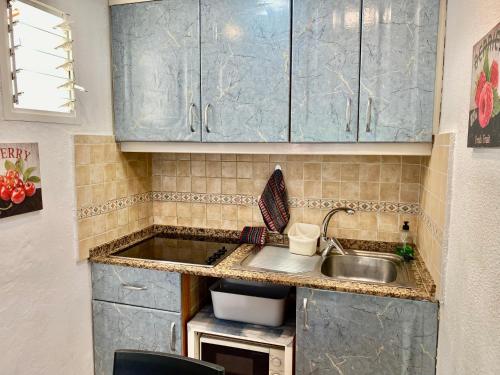 a kitchen with blue cabinets and a sink at Sun Dream Bungalow in San Bartolomé