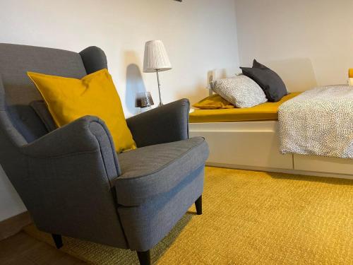 a living room with a chair and a bed at Palheiro da Moenda in Lajes das Flores