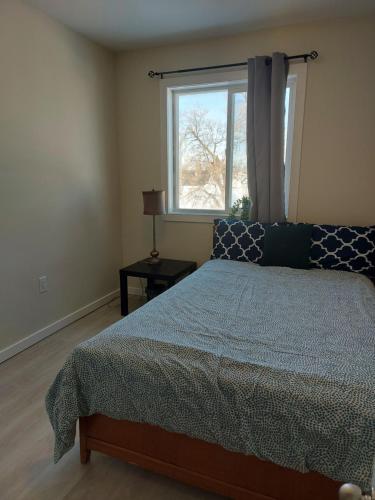 - une chambre avec un lit et une fenêtre dans l'établissement Harbison, à Winnipeg