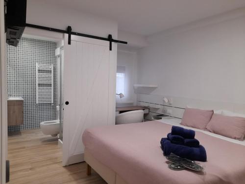 a white bedroom with a bed and a bathroom at Home Sweet Home Main St Pamplona in Pamplona