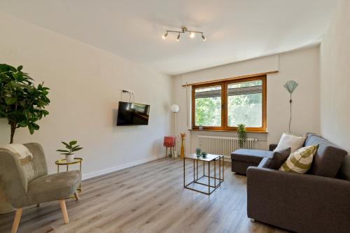 a living room with a couch and a tv at Haus Blaue Traube mit moselblick in Ediger-Eller