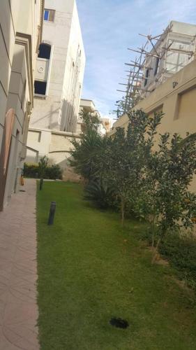 a grassy yard next to a building with trees at Super luxurious villa with large landscape areas in Cairo