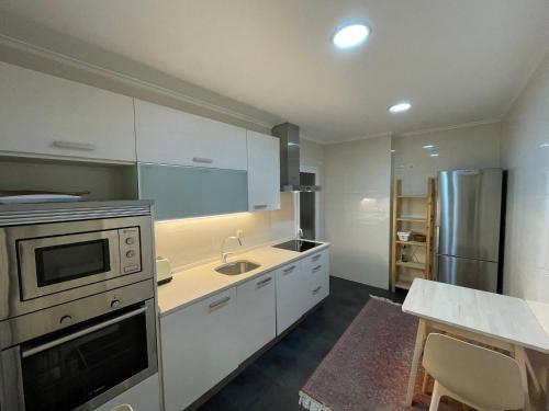 une cuisine avec un évier et une cuisinière four supérieur dans l'établissement Luminoso apartamento en el centro de San Sebastián, à Saint-Sébastien