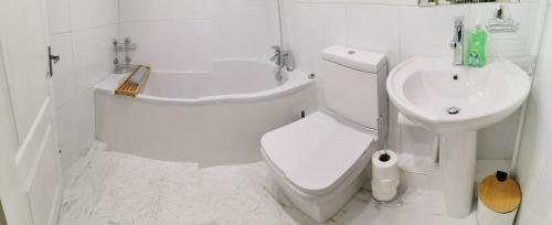 ein weißes Bad mit einem WC und einem Waschbecken in der Unterkunft Hinchley House - Your Manchester Haven in Manchester