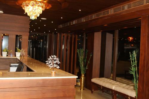 a lobby with a bar with benches and a chandelier at Retrieve Health & Wellness in Cochin
