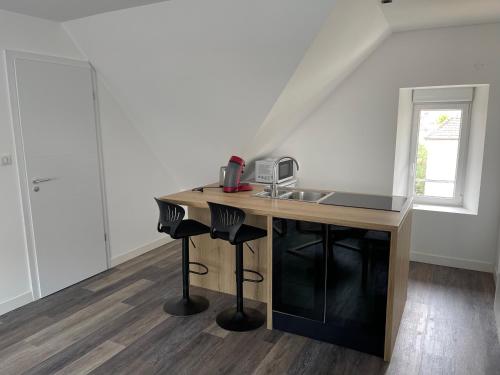 uma cozinha com um lavatório e um balcão com bancos em Le 33 le Haut em Belfort