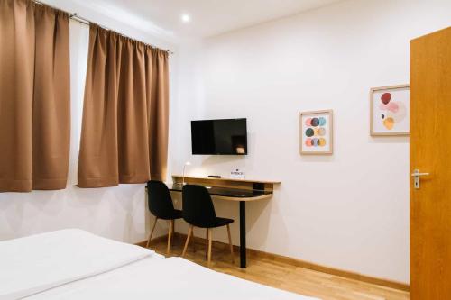 sypialnia z biurkiem, dwoma krzesłami i telewizorem w obiekcie Apartman Diófa w mieście Keszthely