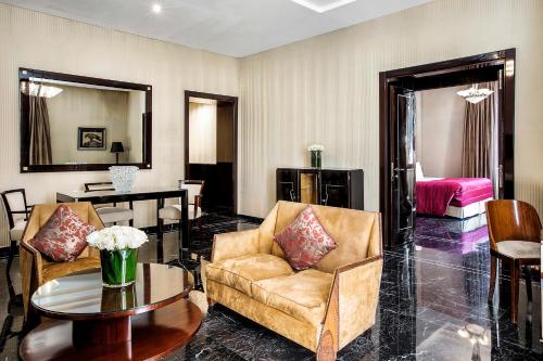 a living room with two chairs and a table at Baglioni Hotel Regina - The Leading Hotels of the World in Rome