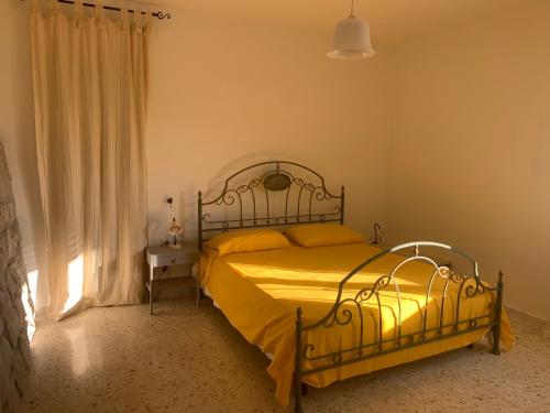 マティーノにあるDependance di Villa Incantoのベッドルーム1室(黄色いシーツ付きのベッド1台、窓付)
