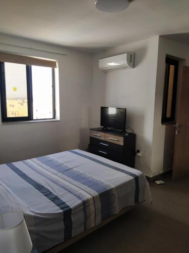ein Schlafzimmer mit Bett und Flachbildfernseher in der Unterkunft Perfect value apartment in St Paul's Bay