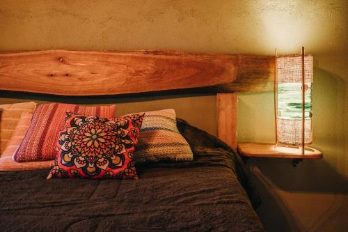 a bedroom with a bed with a wooden head board at Chalé Refugio da Pedra SP in São Bento do Sapucaí