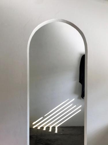 a hallway with a white wall and an archway at Ananda Atins in Atins