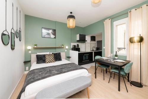 sypialnia z łóżkiem i stołem oraz kuchnia w obiekcie Art Déco Champagne & Spa w mieście Reims