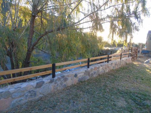 a wooden fence next to a stone wall at Base Manzano in Tunuyán