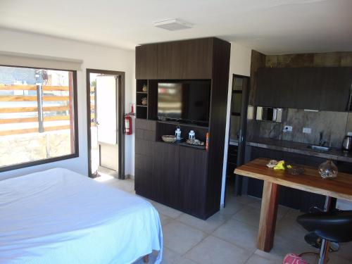 Dormitorio con cama, escritorio y TV en Base Manzano en Tunuyán