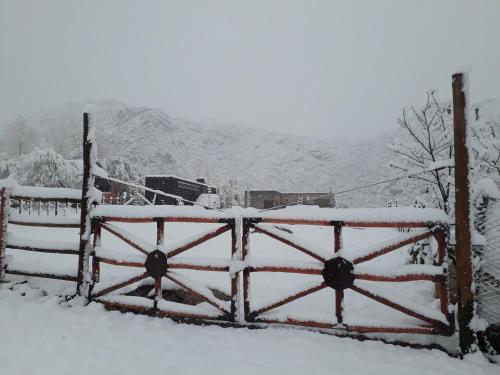 a gate covered in snow with a mountain in the background at Base Manzano in Tunuyán