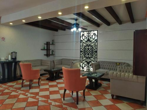un vestíbulo con sofás, sillas y una mesa en Hotel Los Girasoles en Tepic