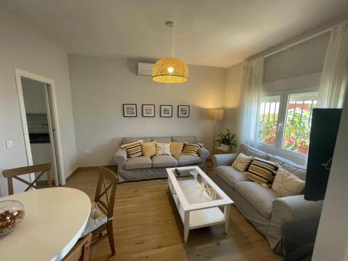 a living room with a couch and a table at Casa 1ª linea de playa Benajarafe in Benajarafe