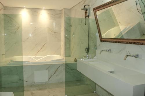a bathroom with a sink and a shower and a mirror at Roma Hotel in Bacabal