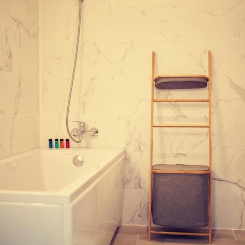 a bathroom with a white tub and a towel ladder at Cosmic Studios NorD10 By Alezzi in Năvodari