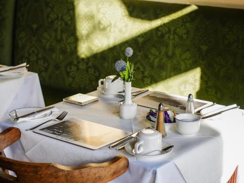 a table with a white table cloth and utensils at Rosehall Hotel in Edinburgh