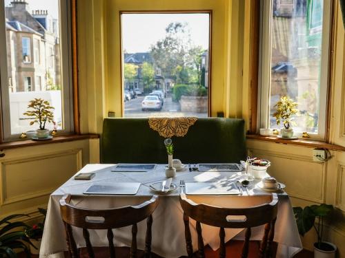a table in a room with a window at Rosehall Hotel in Edinburgh