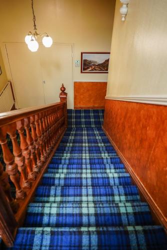an empty room with a staircase with blue tiles at Rosehall Hotel in Edinburgh