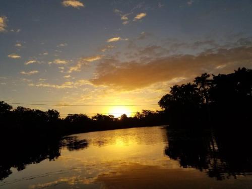 una puesta de sol sobre un río con la puesta de sol en River Bend Resort Bze en Ciudad de Belice