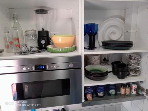 a kitchen with a microwave and some plates and dishes at Kalmarapartment in Kalmar