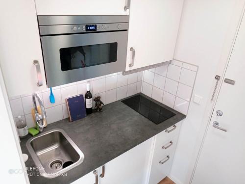 a small kitchen with a sink and a microwave at Kalmarapartment in Kalmar