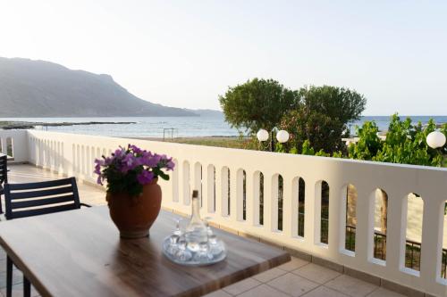 a table with flowers on top of a white fence at Gramvoussa Bay in Kissamos