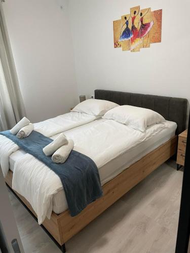 sypialnia z dużym łóżkiem z białą pościelą i poduszkami w obiekcie Apartman Ivanica w mieście Lukoran
