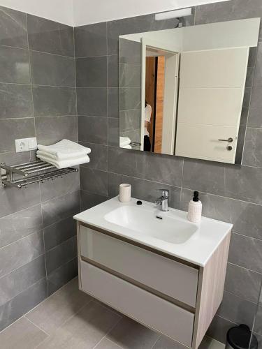 a bathroom with a sink and a mirror at Apartman Ivanica in Lukoran