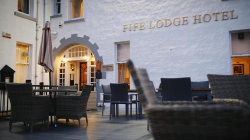 Fife Lodge Hotel في بانف: مجموعة كراسي وطاولات امام الفندق