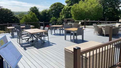 a deck with tables and chairs on a balcony at Fife Lodge Hotel in Banff