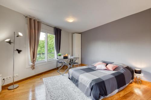 a bedroom with a bed and a desk and a window at Studio Moderne & Cosy Proche Paris in Rosny-sous-Bois
