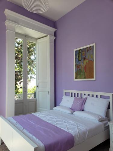 - une chambre avec des murs violets et un grand lit dans l'établissement Caluga House, à Piano di Sorrento