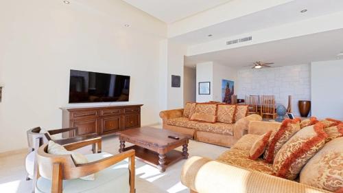 ein Wohnzimmer mit zwei Sofas und einem Fernseher in der Unterkunft Encanto Living Penthouse 1202 by Kivoya in Playa Encanto
